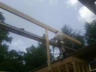 Carpenter setting a ridge beam over a new addition frame in Scarborough