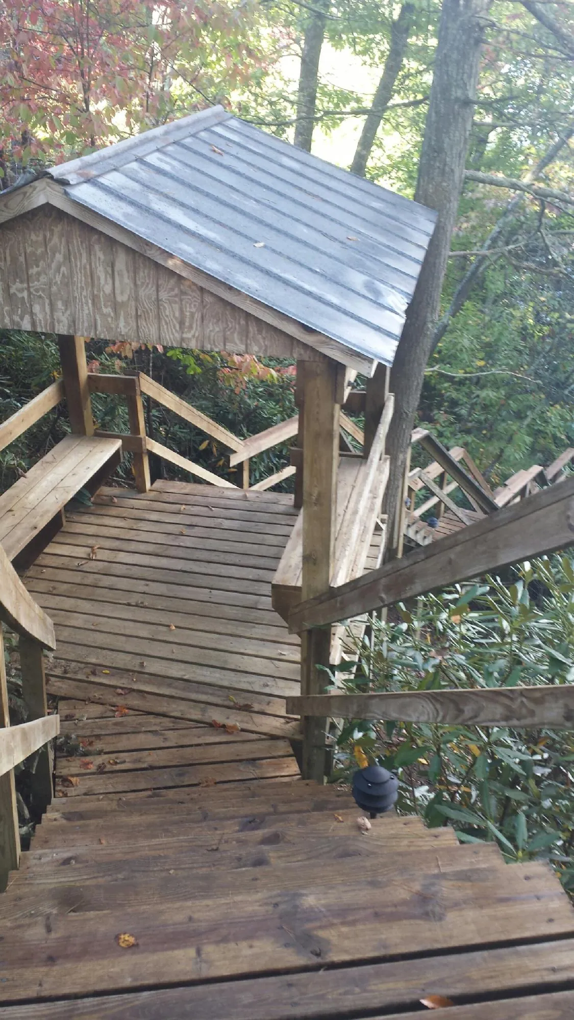 Metal roofed shelter over wooden steps on a wooded walkway — Skylight Repair & Installation work by our crew in Scarborough
